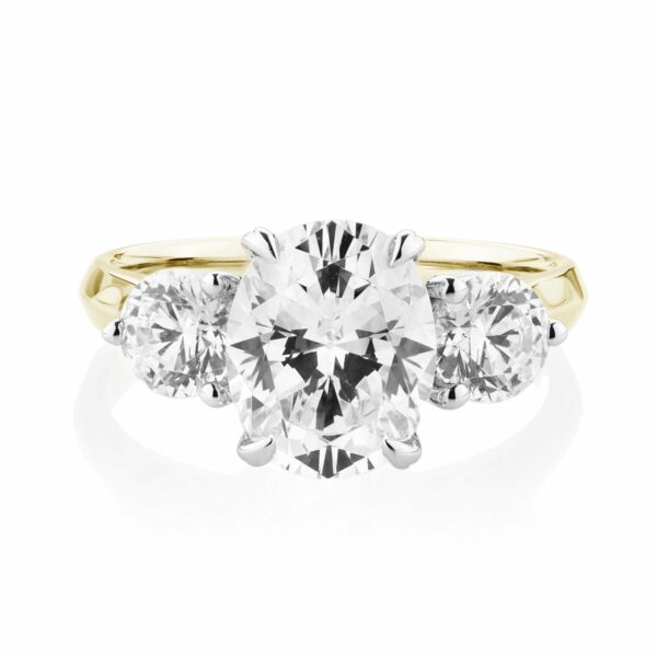 Three stone ring with 3.46 carats* of diamond simulants in 10 carat yellow and white gold
