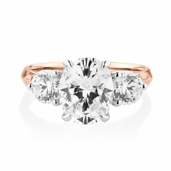 Three stone ring with 3.46 carats* of diamond simulants in 10 carat rose and white gold