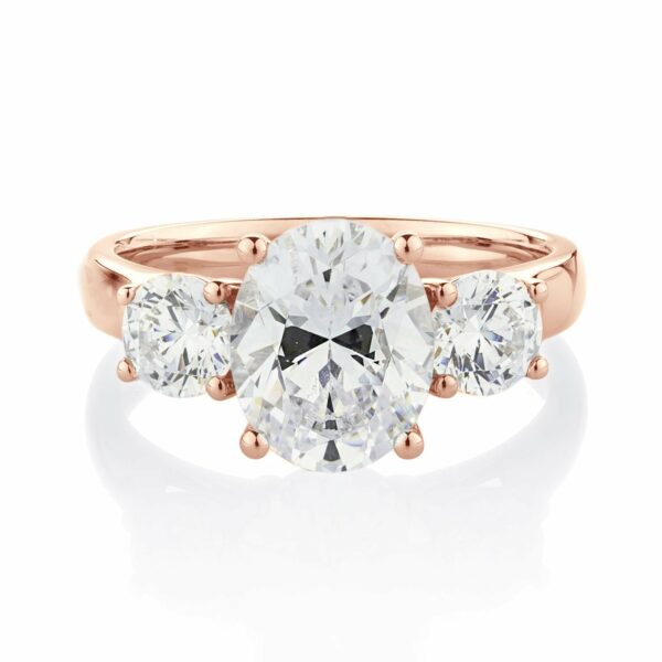 Three stone ring with 3.5 carats* of diamond simulants in 10 carat rose gold